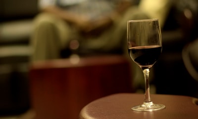浅摄影葡萄酒杯的酒关注棕色木桌上
